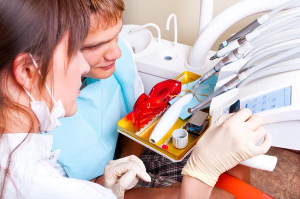 Dentista explicando os detalhes de uma imagem de raio-X para seu paciente — Fotografia de Stock