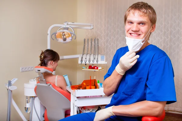 Mladý zubař ve své kanceláři se dívá na diváka — Stock fotografie
