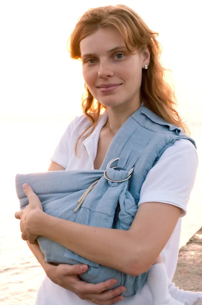 Jonge moeder met haar baby in sling — Stockfoto