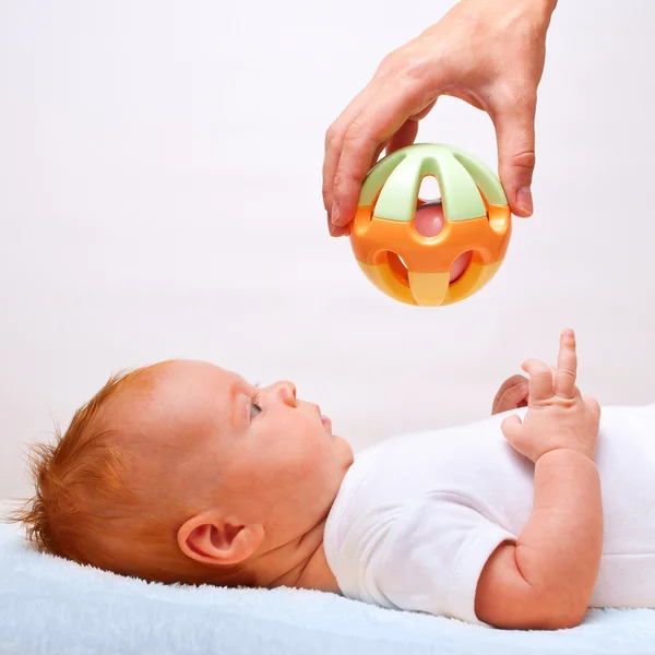 Kleine legdatum baby met speelgoed — Stockfoto