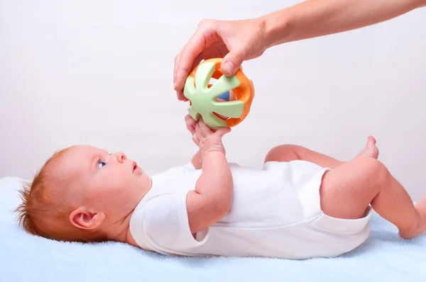 Kleine legdatum baby met speelgoed — Stockfoto