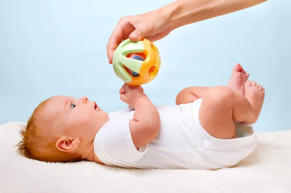 Pequeno bebê de postura com brinquedo — Fotografia de Stock