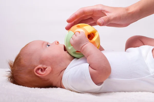 Pequeño bebé tendido con juguete — Foto de Stock