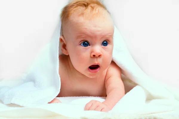 Pequeno bebê sob toalha branca — Fotografia de Stock