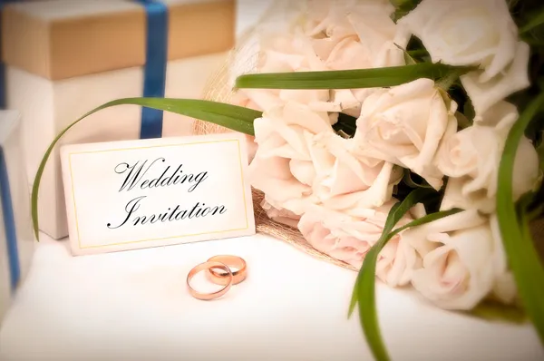 Svatební pozvánky s kroužky, dárky a růže — Stock fotografie