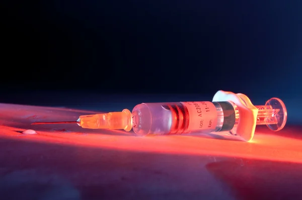 赤い光に照らされた注射器 — ストック写真