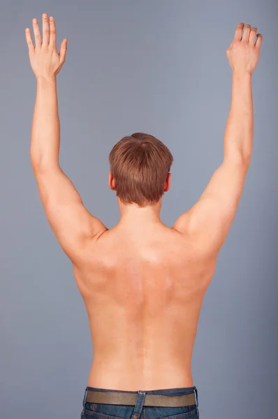 Vista posteriore di un giovane muscoloso con le braccia alzate — Foto Stock