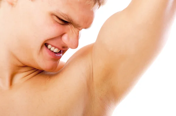 Närbild av ung man sniffar hans armhåla isolerad på vit bakgrund — Stockfoto