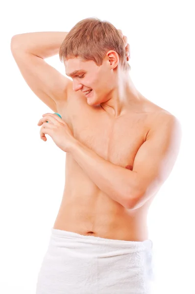 Fechar-se de um jovem homem muscular usando um antitranspirante isolado sobre branco — Fotografia de Stock