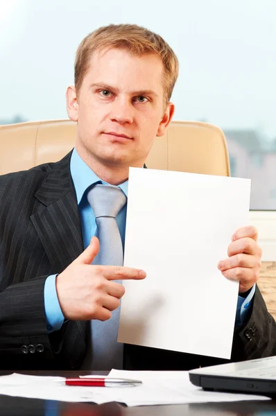Jovem empresário segurando papel em branco — Fotografia de Stock