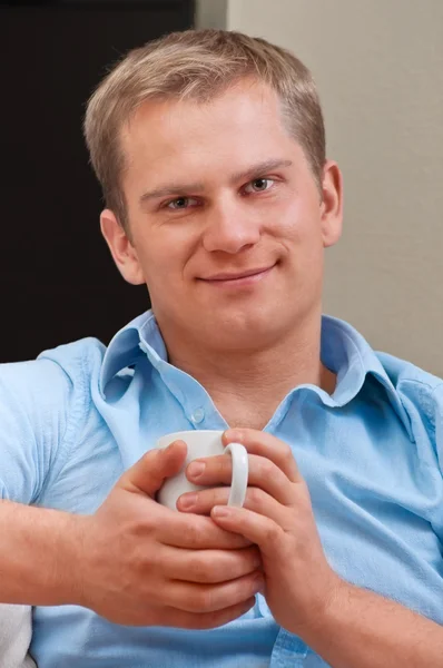 Portret młodego mężczyzny szczęśliwy z filiżanką kawy - wnętrze — Zdjęcie stockowe
