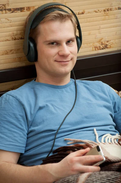 Dit is een foto van het leggen van jonge man muziek luisteren — Stockfoto