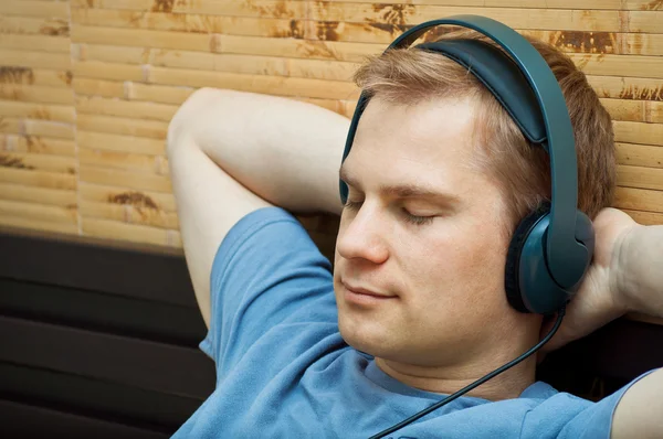Esta es una fotografía de un joven tendido escuchando música — Foto de Stock