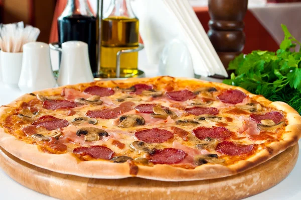 Closeup de uma pizza com salame e cogumelos — Fotografia de Stock