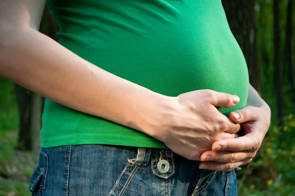 一个怀孕的女人，在她的肚子上着她的手的特写 — 图库照片