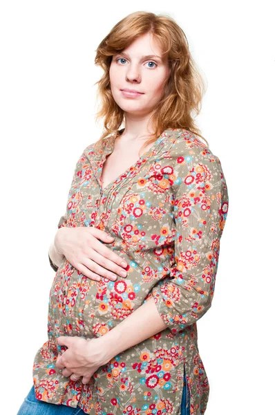 Nachdenkliche junge schwangere Frau hält ihre Hände auf ihrem Bauch — Stockfoto