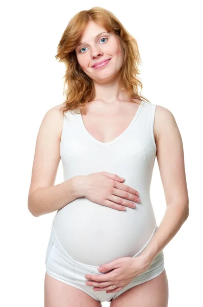 Jonge zwangere vrouw die haar handen op haar buik — Stockfoto
