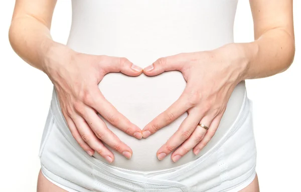 心臓形状記号を作る若い妊娠中の女性のクローズ アップ — ストック写真