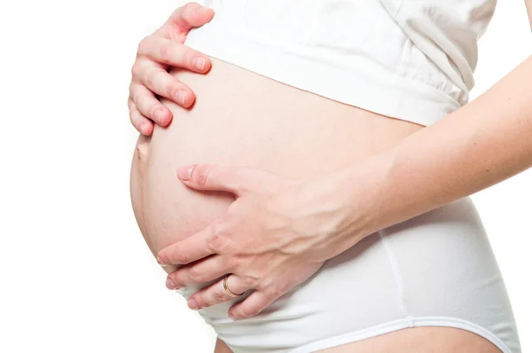 Primo piano di una donna incinta che tiene le mani sulla pancia — Foto Stock