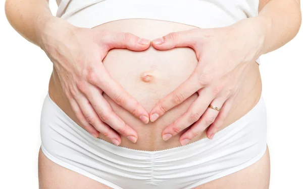 Close-up młodej kobiety w ciąży co kształt serca — Zdjęcie stockowe