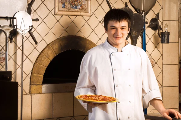 A young chef standing next to oven Royalty Free Stock Images