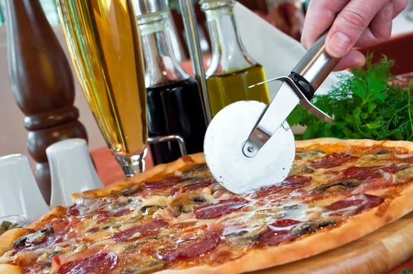 Närbild av en pizza med salami och svamp Stockfoto