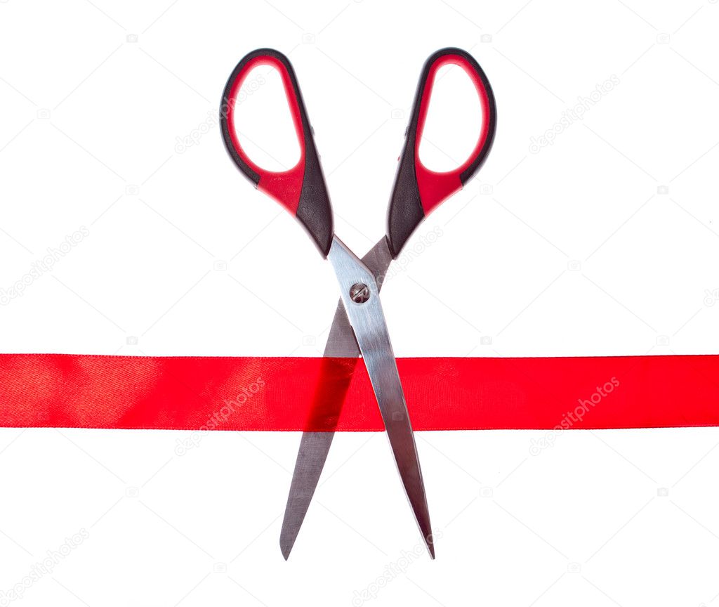 Scissors cutting through red ribbon or tape, isolated on white.