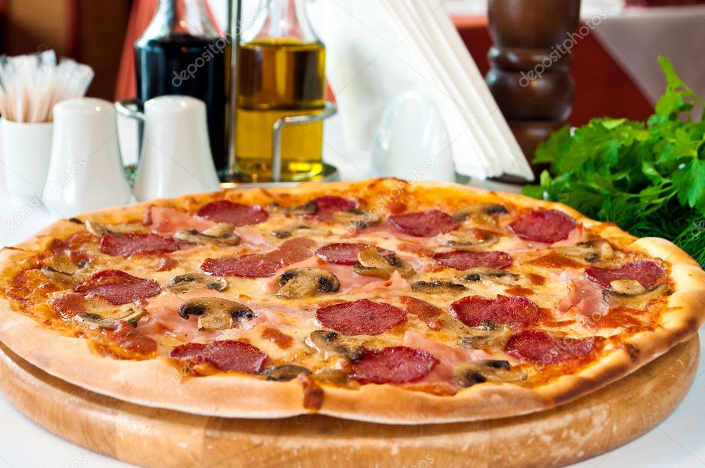 Closeup of a pizza with salami and mushrooms