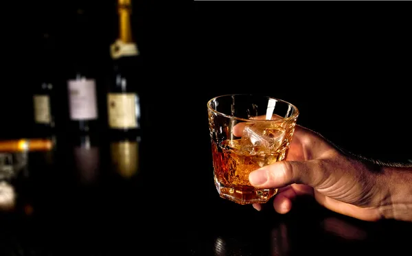 Tenant un verre de whisky à la main — Photo