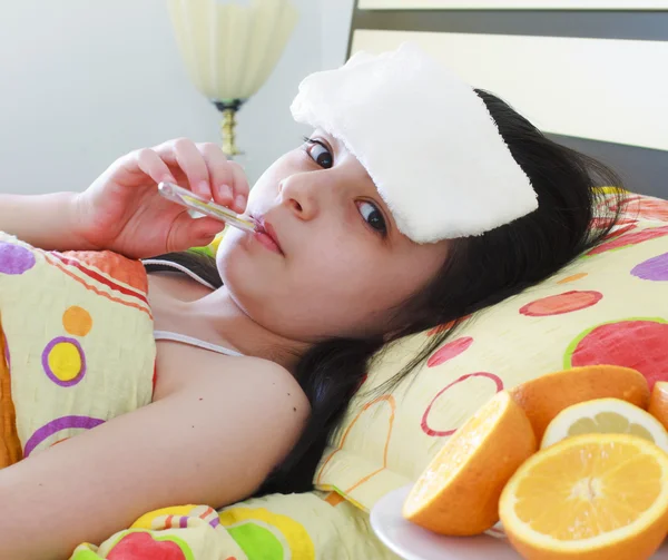Gadis muda sakit dengan termometer di tempat tidur — Stok Foto