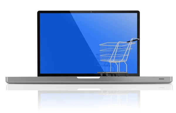 Nákupní košík přes bílý laptop — Stock fotografie