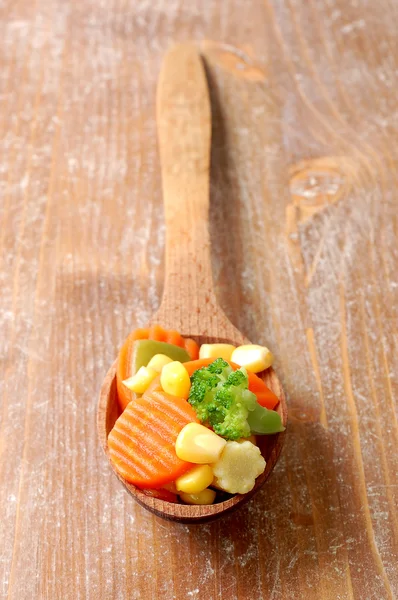 Варена морква солодка кукурудза і брокколі в дерев'яній ложці — стокове фото