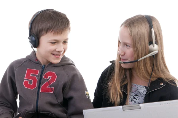 Crianças em fones de ouvido com computadores portáteis — Fotografia de Stock