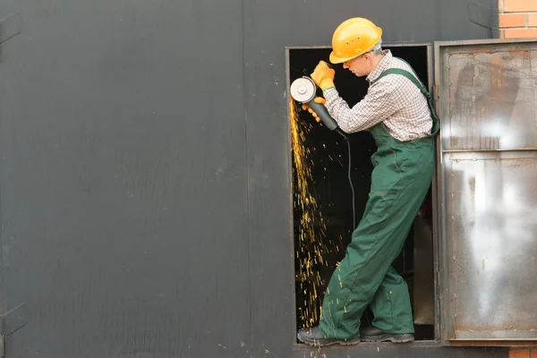 stock image Worker in orange helmet with angle grinder. Full length portrait