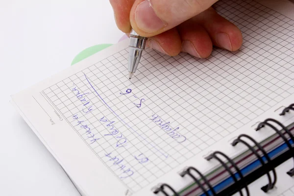 Mão com caneta escreve em caderno — Fotografia de Stock