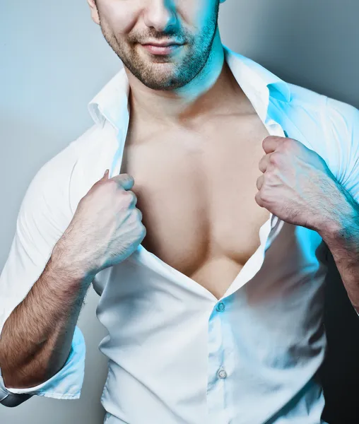 Sexy männliches Modell knöpft sein weißes Hemd auf — Stockfoto