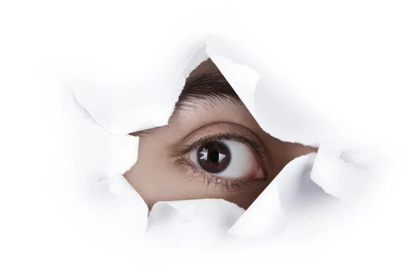 Ojo mirando a través de un agujero de papel — Foto de Stock