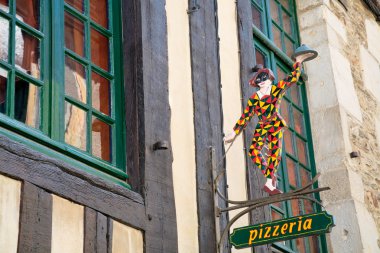 Old harlequin figure under pizzeria clipart