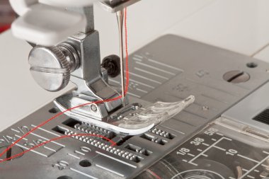Thread in needle of sewing machine closeup clipart