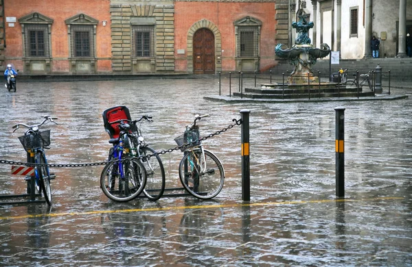 Велосипед на городской площади под дождем — стоковое фото