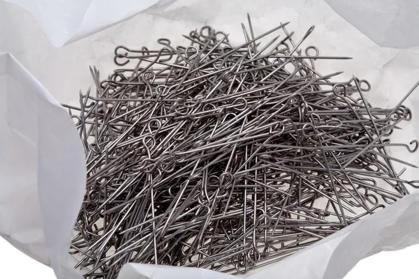 Muitos pinos de alfaiate de aço em pacote de papel desembrulhado — Fotografia de Stock