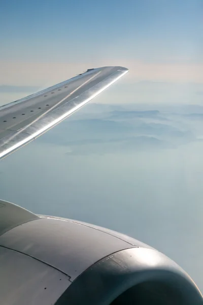 Berge unter dem Flügel eines Flugzeugs — Stockfoto