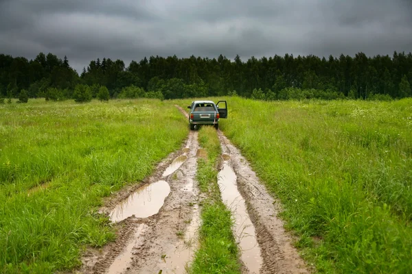Автомобиль на проселочной дороге в день дождя — стоковое фото