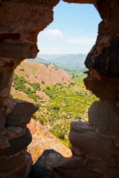 View on lands through gun slot in old Arab-Norman fortress — Stock Photo, Image