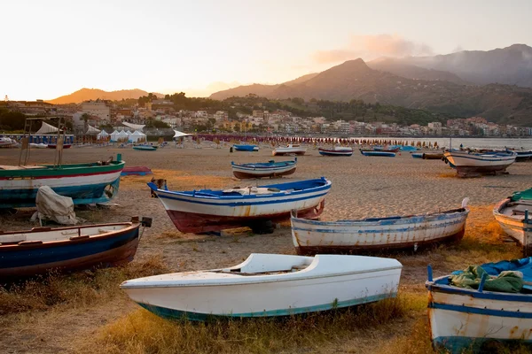 Лодки на пляже на закате — стоковое фото