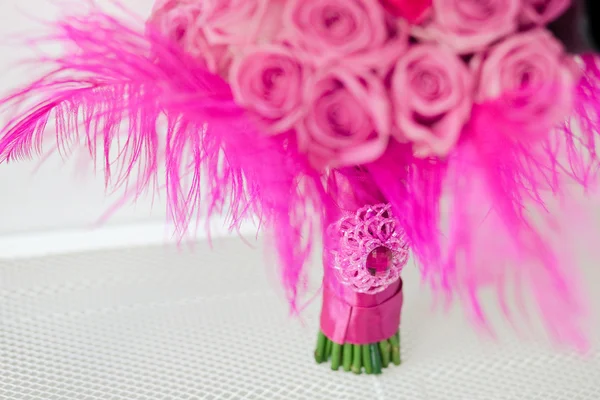 Bridal bouquet of roses with pink tape is on a shelf — Stock Photo, Image