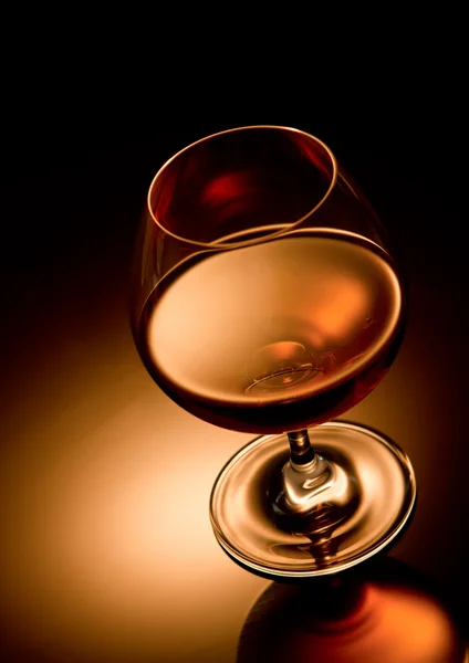 Glas cognac op gouden achtergrond — Stockfoto