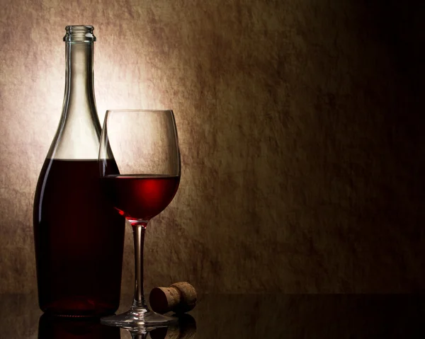 Μπουκάλι με κόκκινο κρασί και γυαλί και σταφύλια — Φωτογραφία Αρχείου