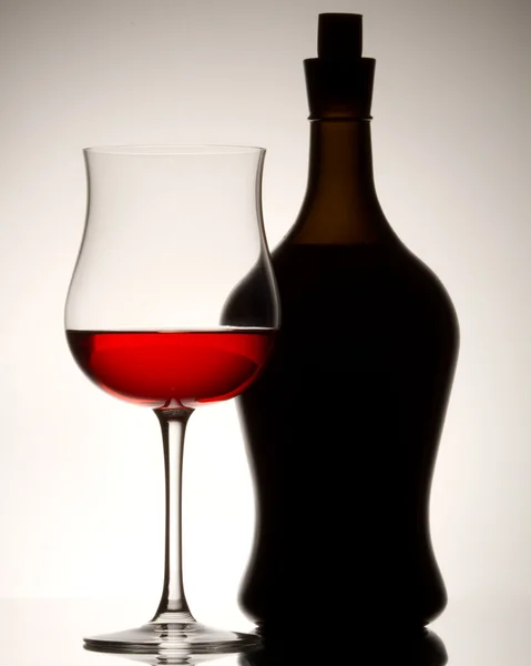 Natureza morta com o copo de vinho tinto e a garrafa — Fotografia de Stock