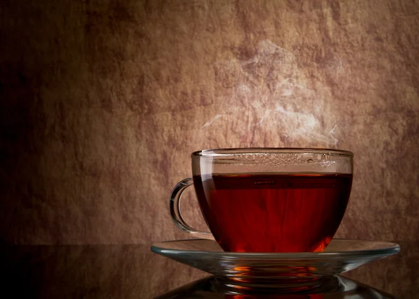 stock image Tea in glass cup on old stone background